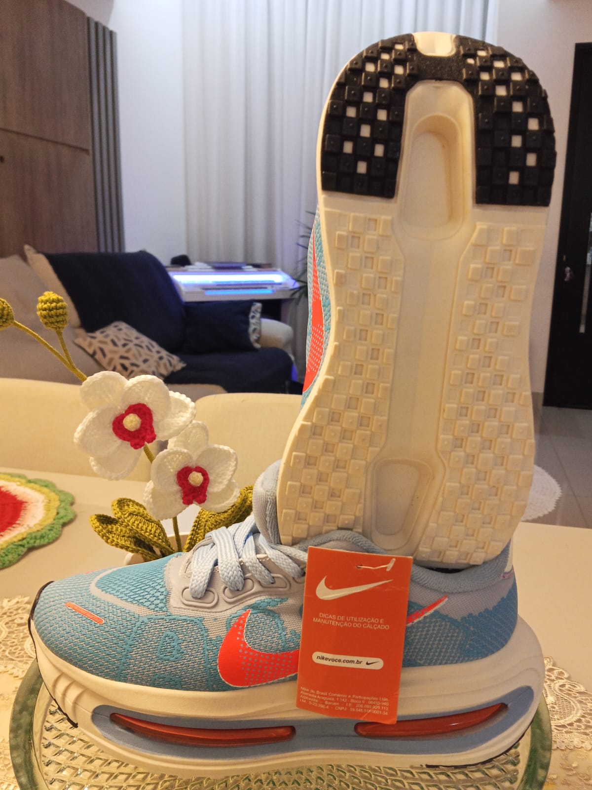 Tênis Nike azul e laranja com solado em exibição